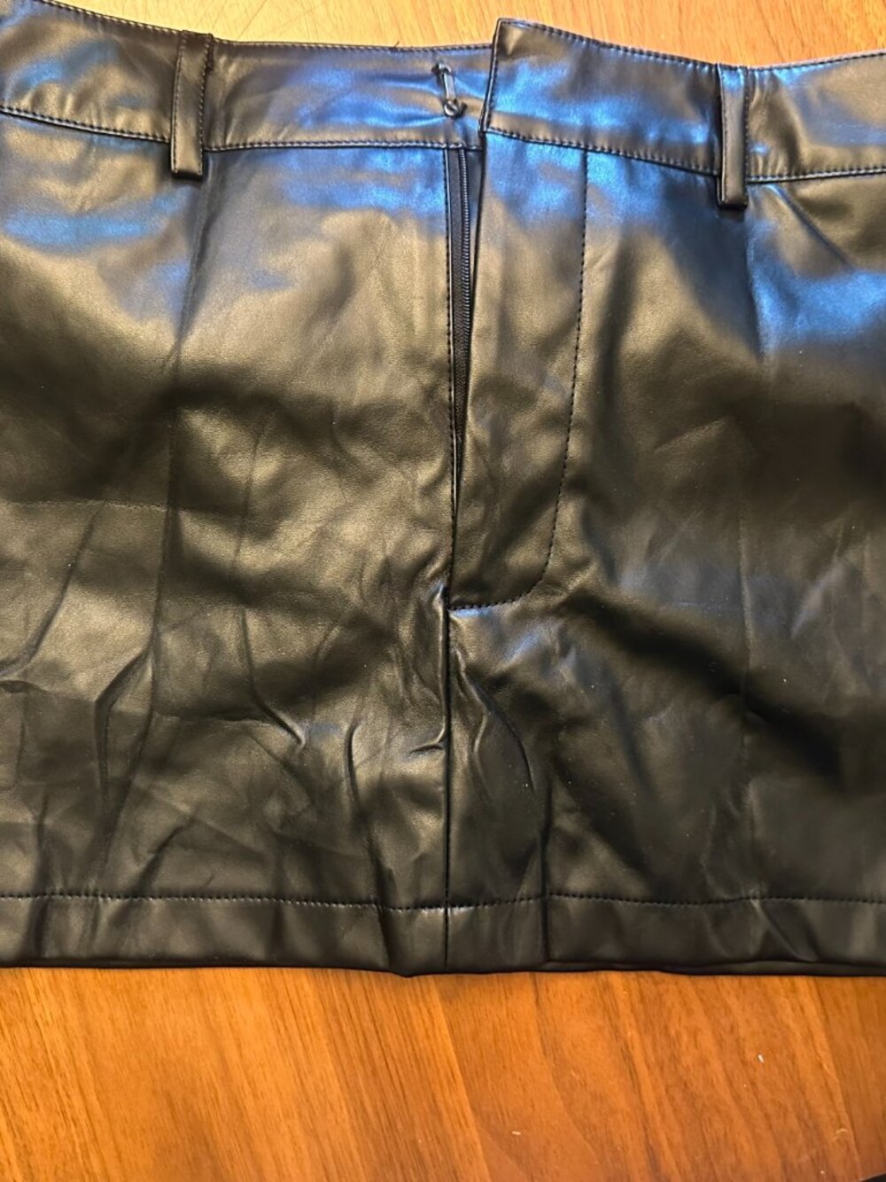 Black faux leather mini-skirt, shorts underneath, size S